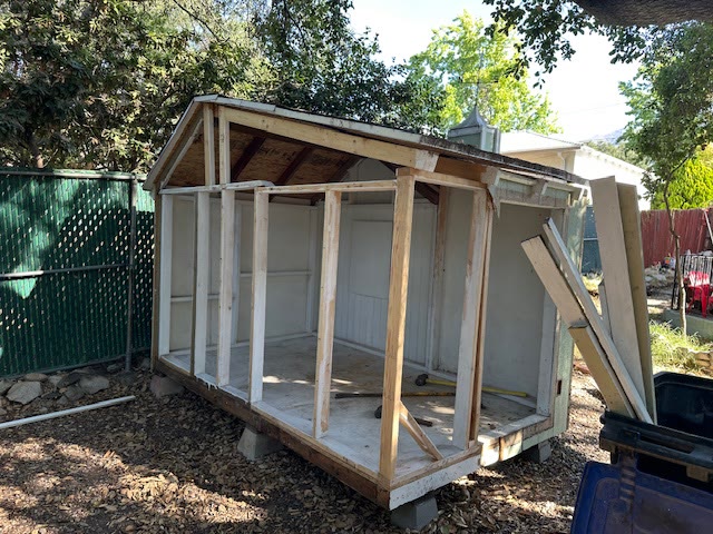 Wood-framed shed being taken down